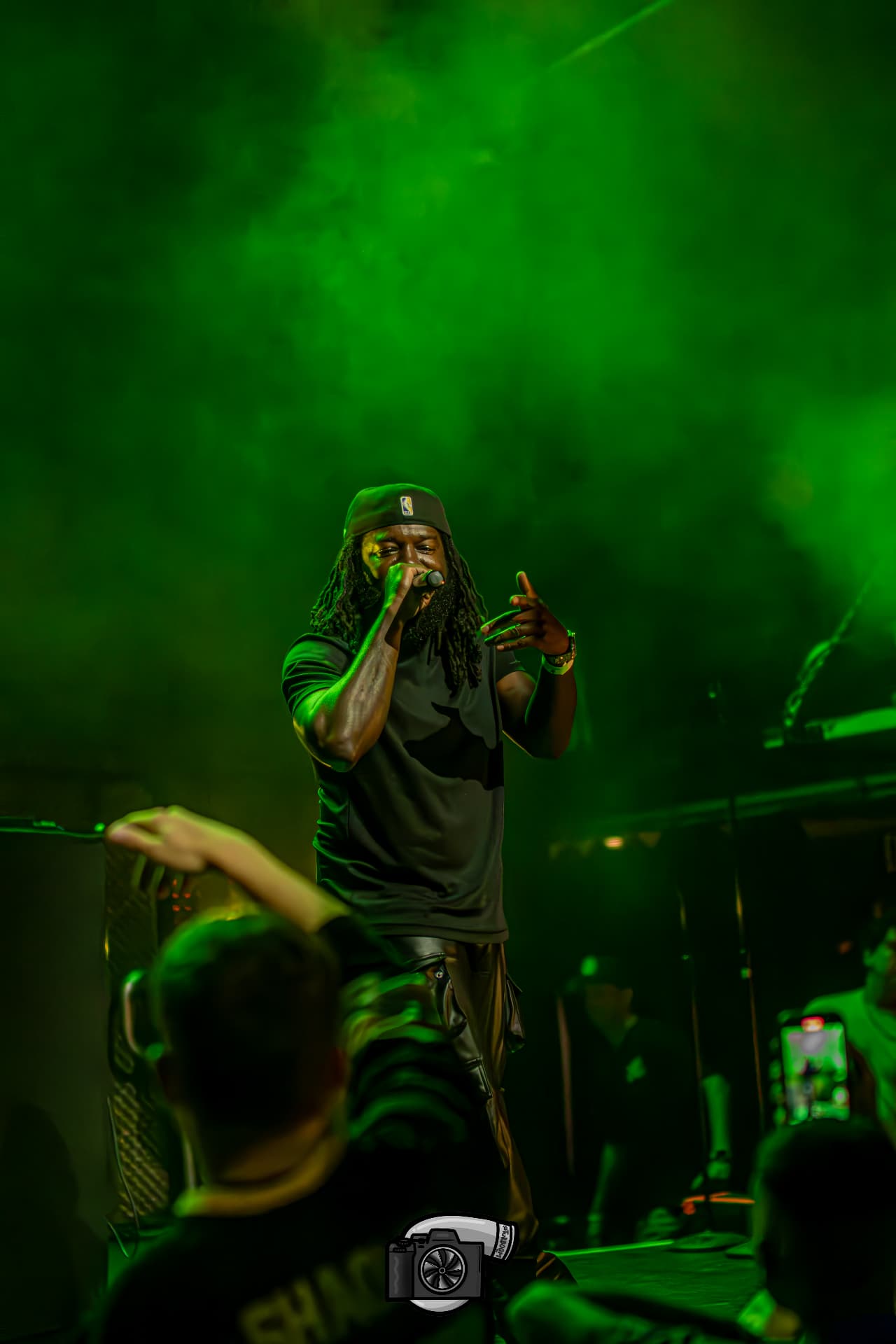 JoethePoet performing beneath green stage lights